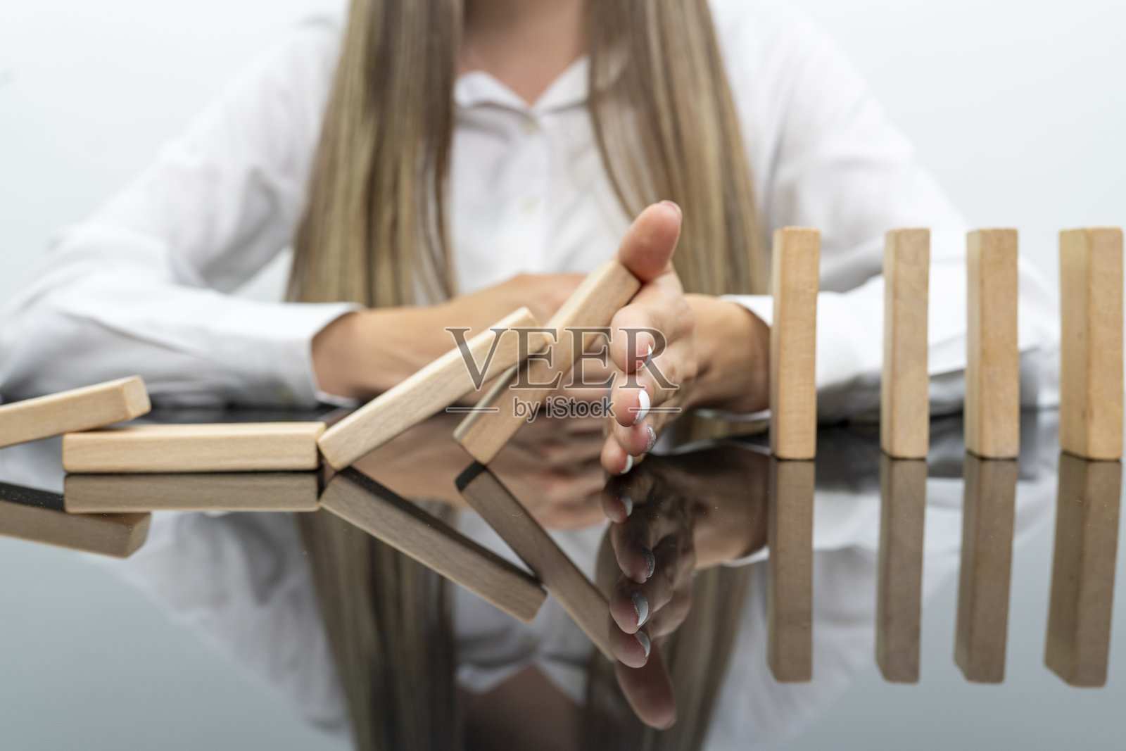 生意人手中的木块停止一种游戏,赌博时放置木块。概念风险管理和战略计划,保障企业成功。照片摄影图片