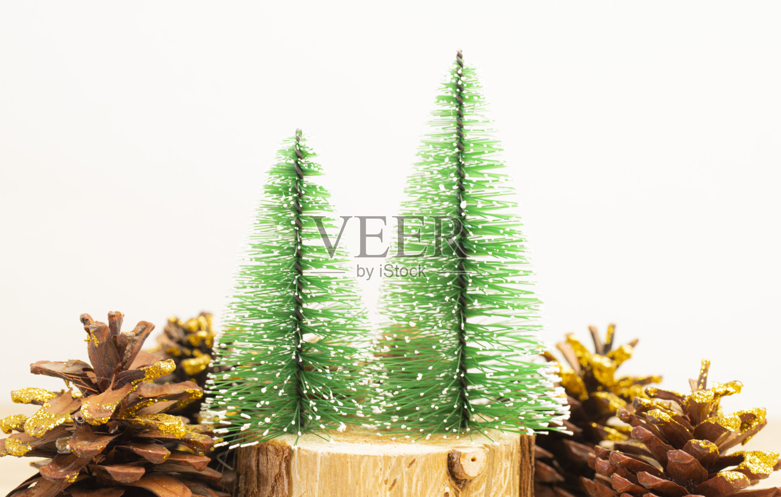 绿色的圣诞树上的圆木和松果,白色的背景和复制空间。照片摄影图片