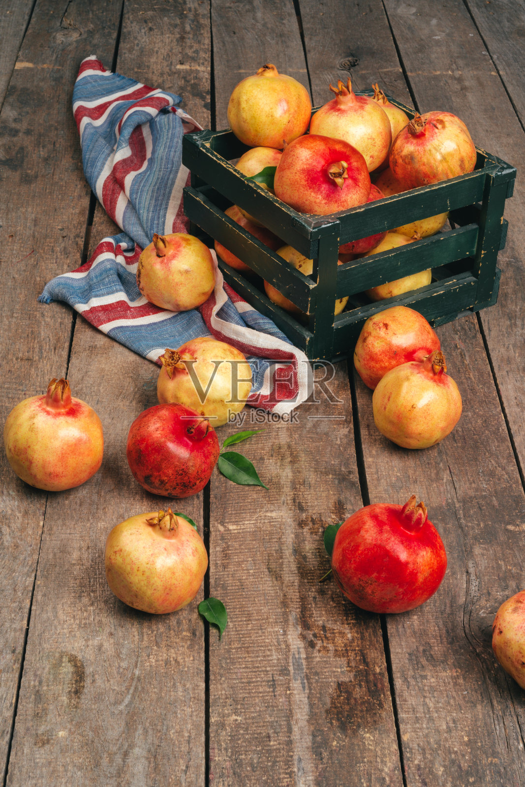 木质背景上一堆成熟的石榴照片摄影图片