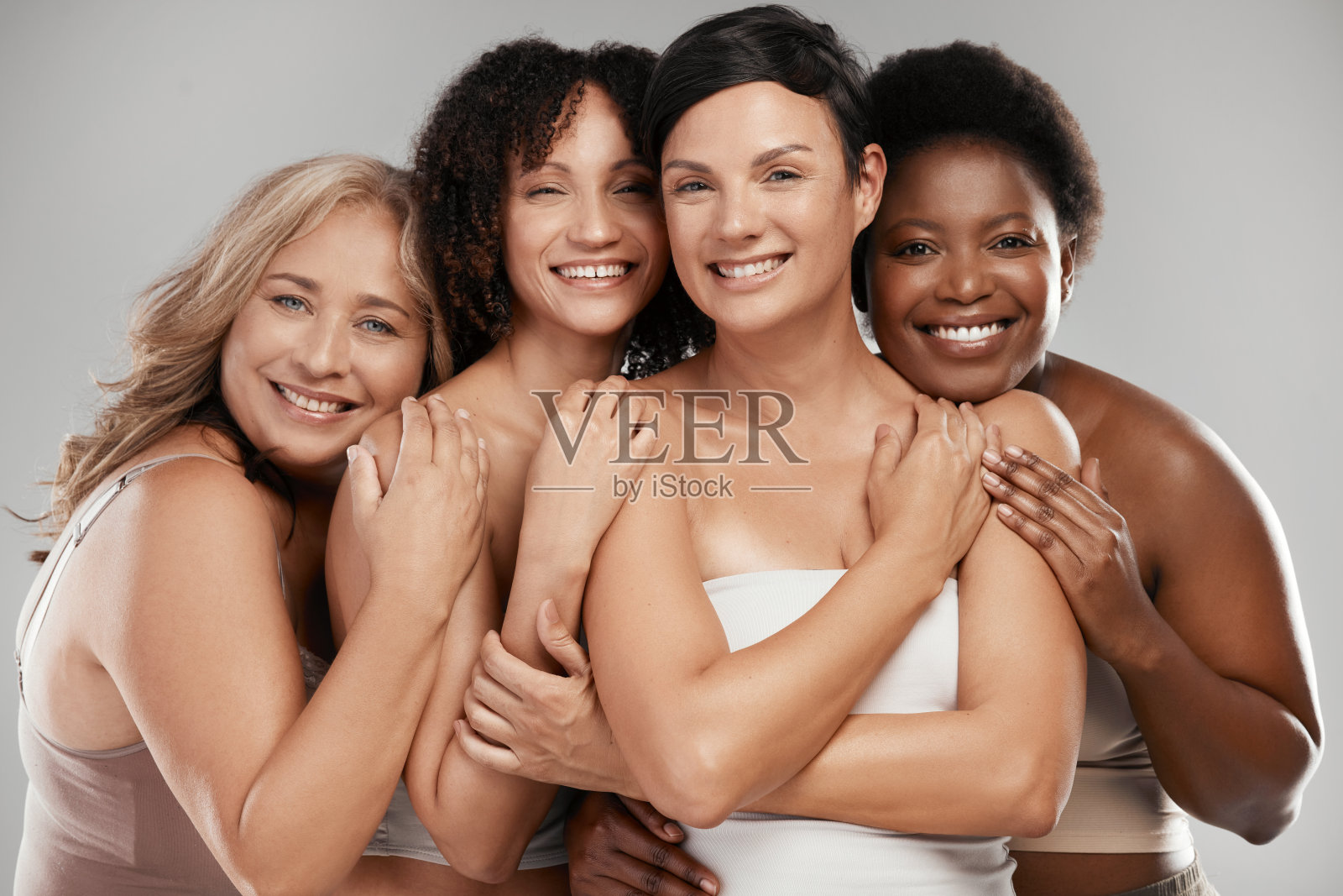 一群不同的女性站在演播室里互相拥抱照片摄影图片