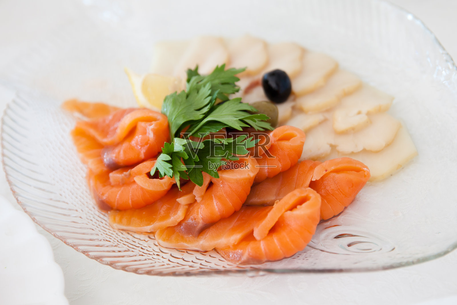 一盘三文鱼片。红鱼片配香草。照片摄影图片