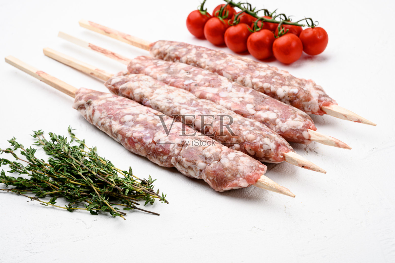 生肉丸肉串,香肠,与烧烤原料,在白石桌子背景照片摄影图片