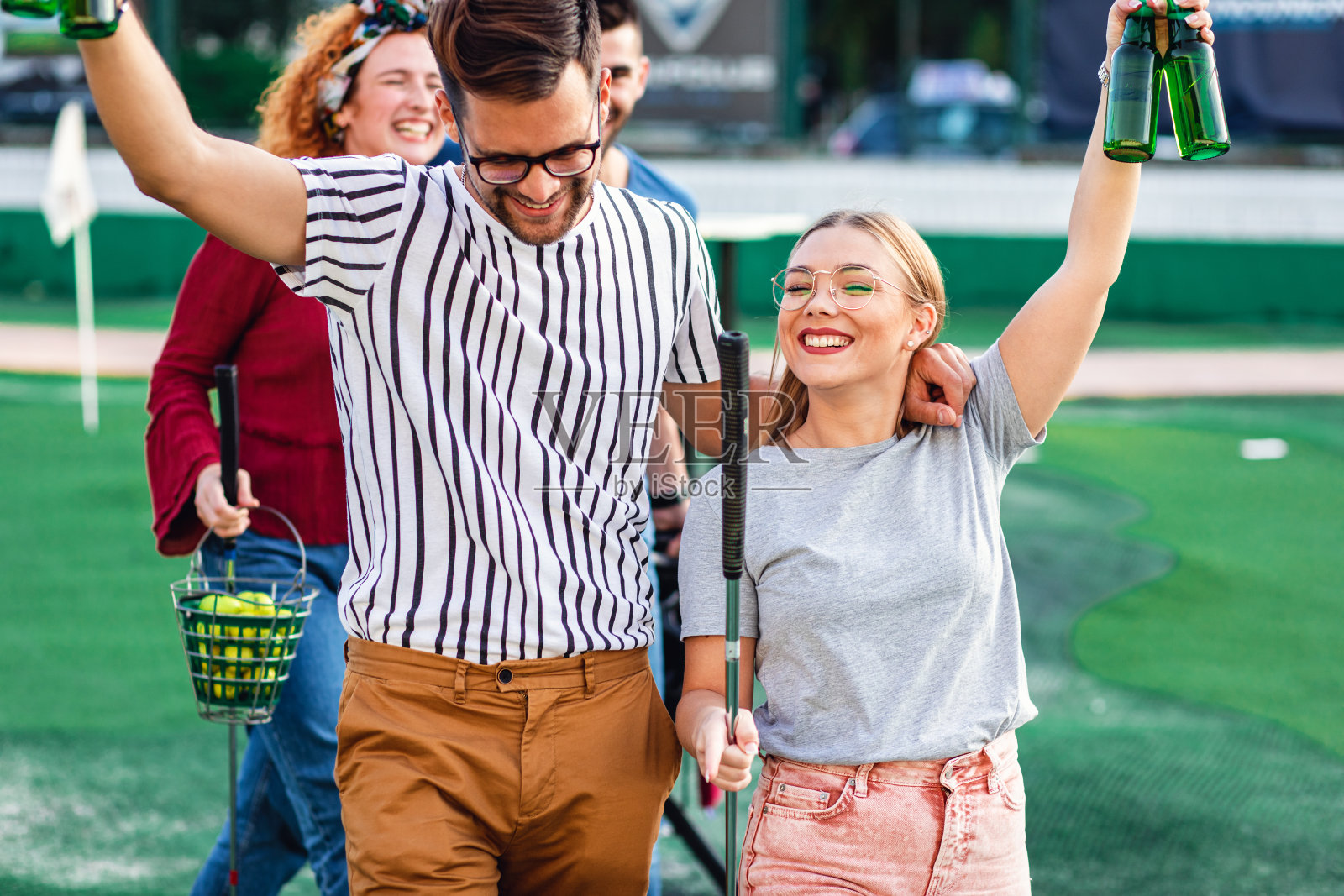 一群朋友在城市里一起玩迷你高尔夫。照片摄影图片