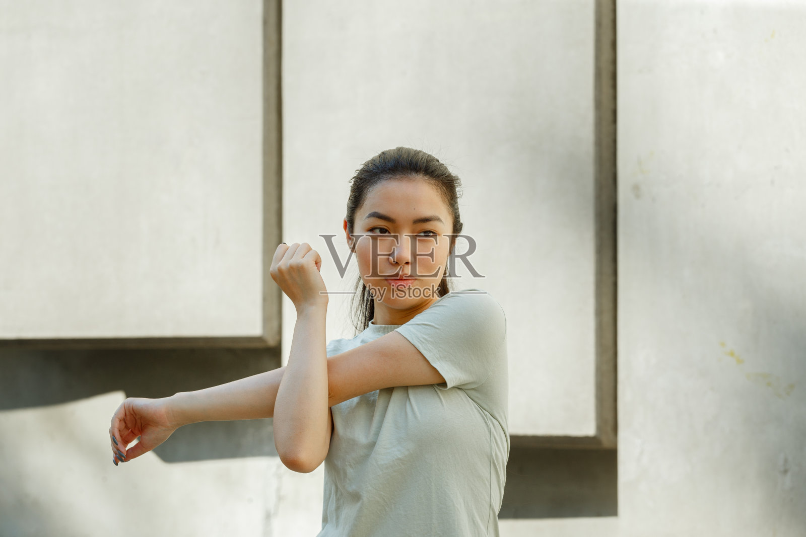 穿着t恤的亚洲女人在城市街道上做运动照片摄影图片