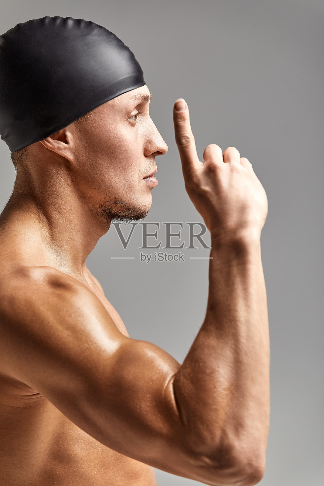 一名年轻的职业游泳运动员举起手指表示空白照片摄影图片