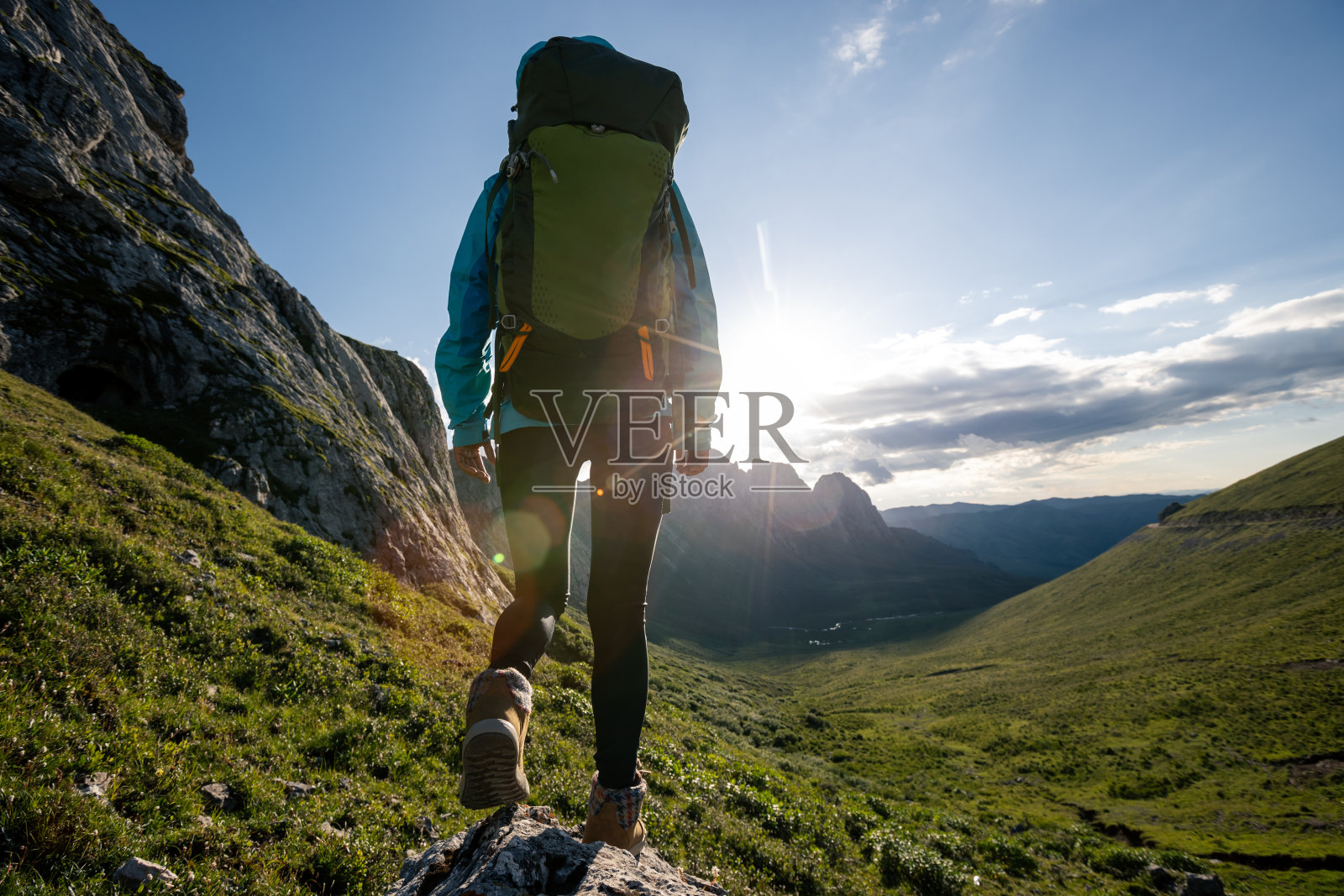 成功女性背包客徒步于日落高山山顶照片摄影图片
