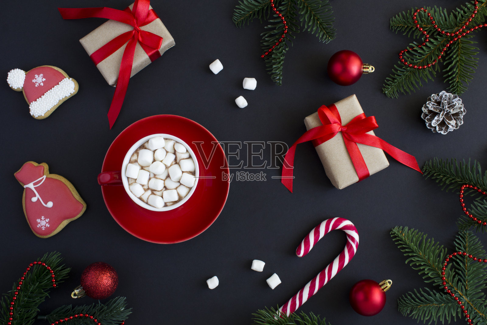 红色杯子里的热巧克力和棉花糖,黑色背景上的圣诞构图。前视图。照片摄影图片