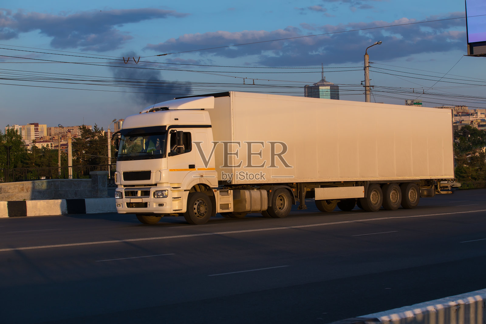 卡车在城市的背景下沿着街道行驶照片摄影图片