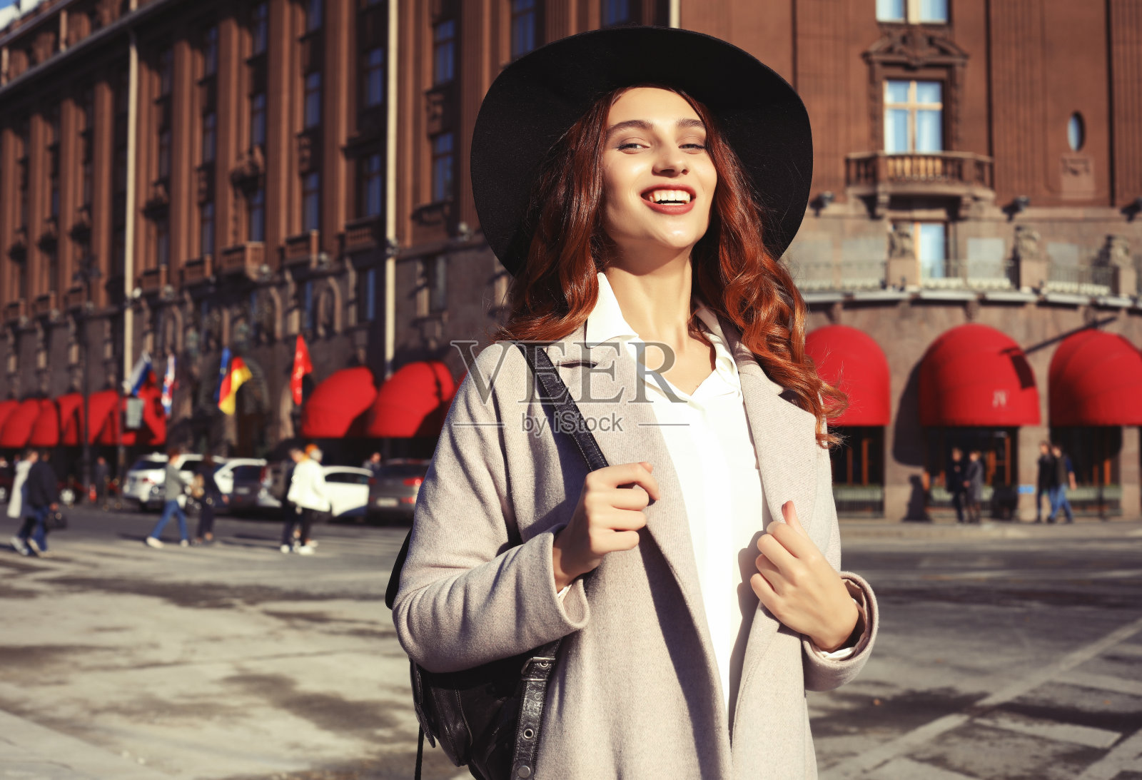户外的画像中雍容美丽快乐微笑的女人戴着时髦的帽子、外套照片摄影图片
