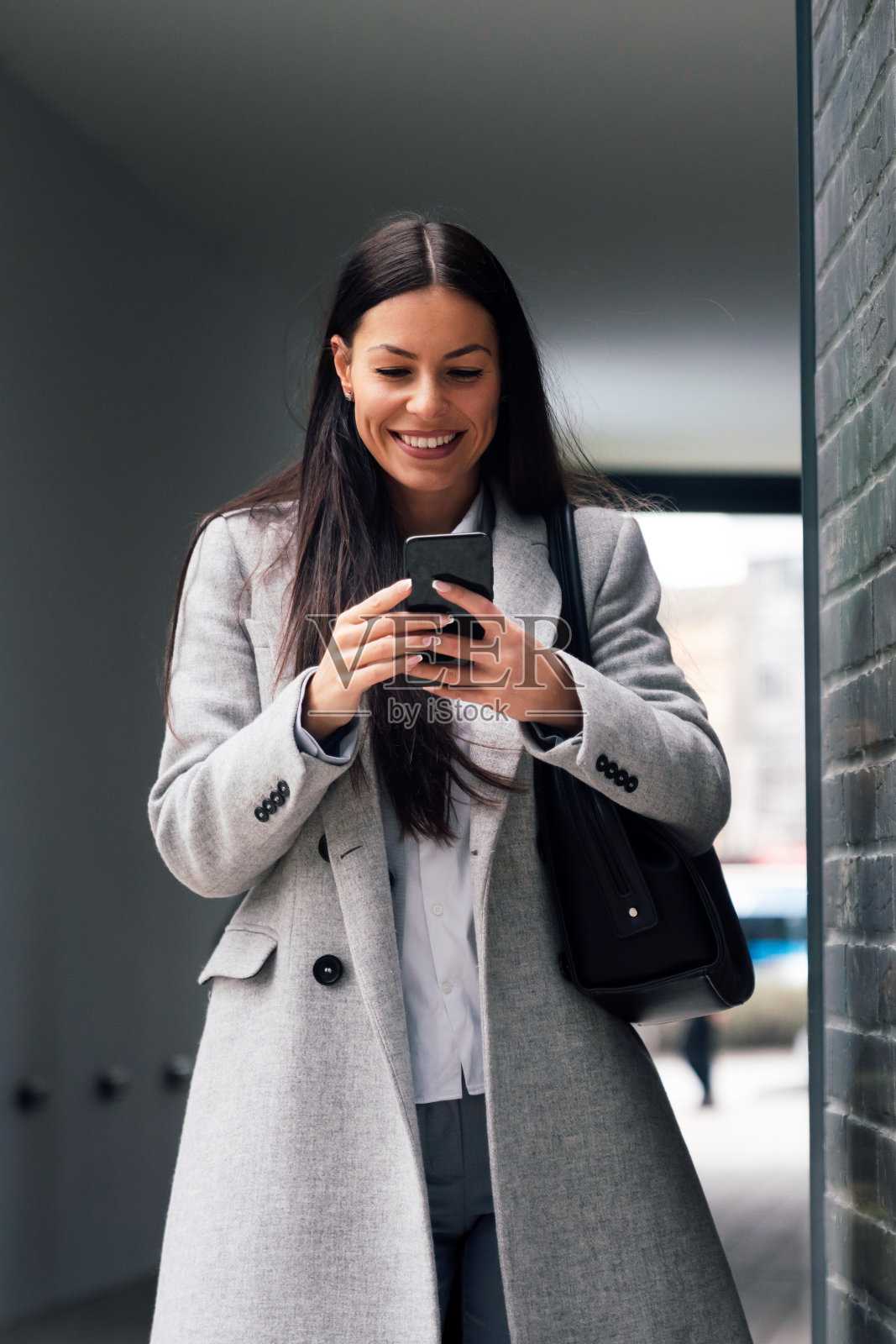 成功的女商人或企业家在户外散步时使用智能手机照片摄影图片