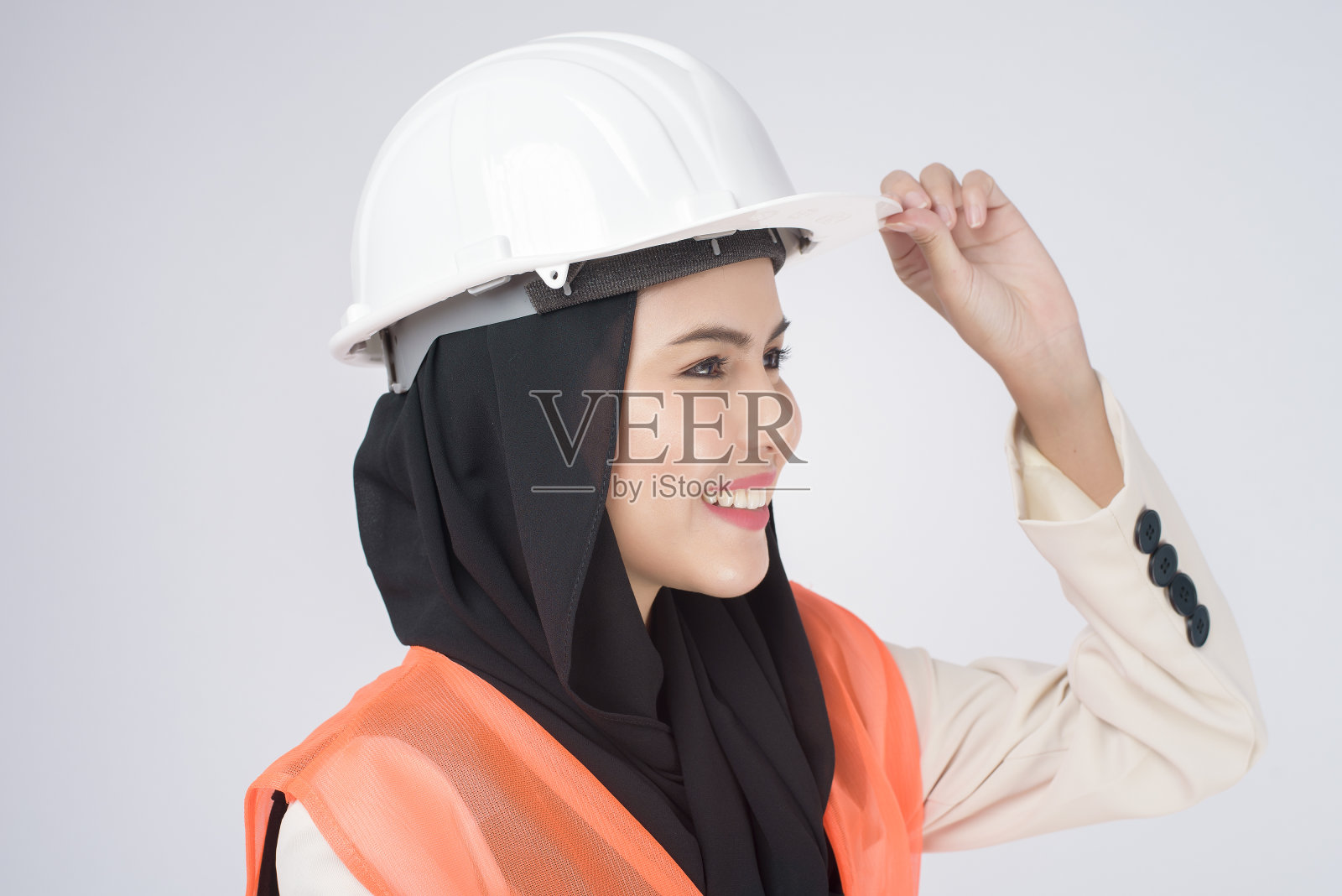 一名穆斯林女工程师在白色背景的摄影棚上戴着防护头盔照片摄影图片