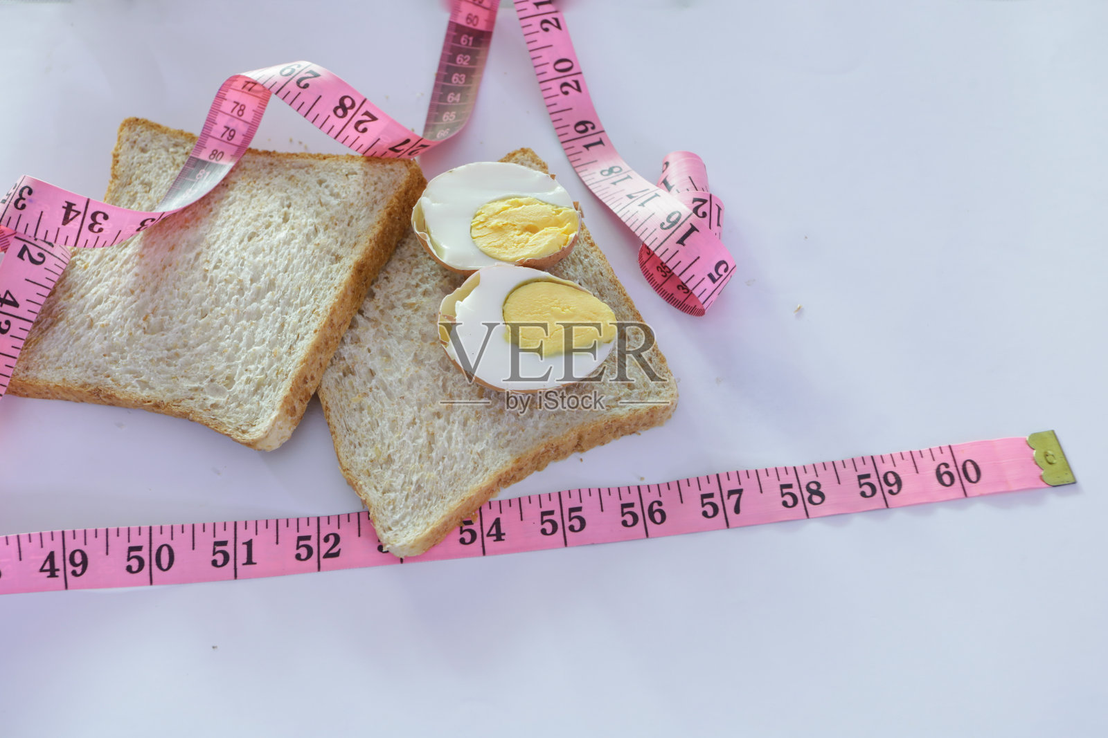 全麦面包、鸡蛋和卷尺,健康饮食理念,降低身体脂肪含量照片摄影图片