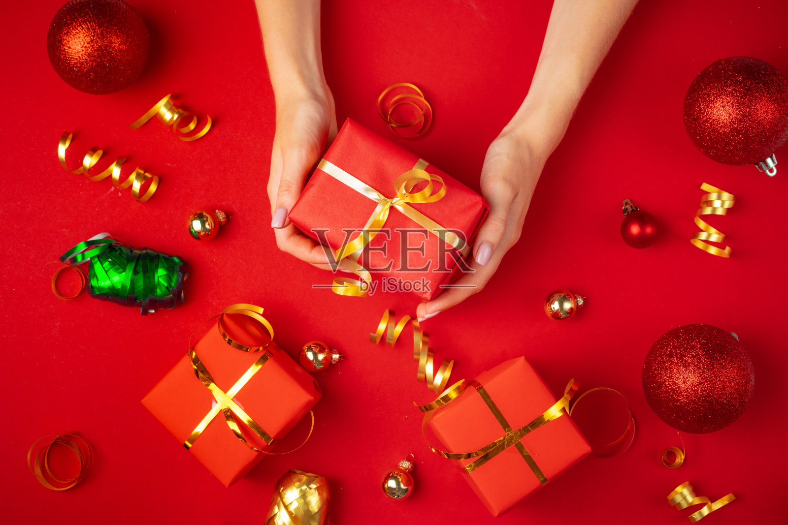 女性手握礼物在红色背景照片摄影图片