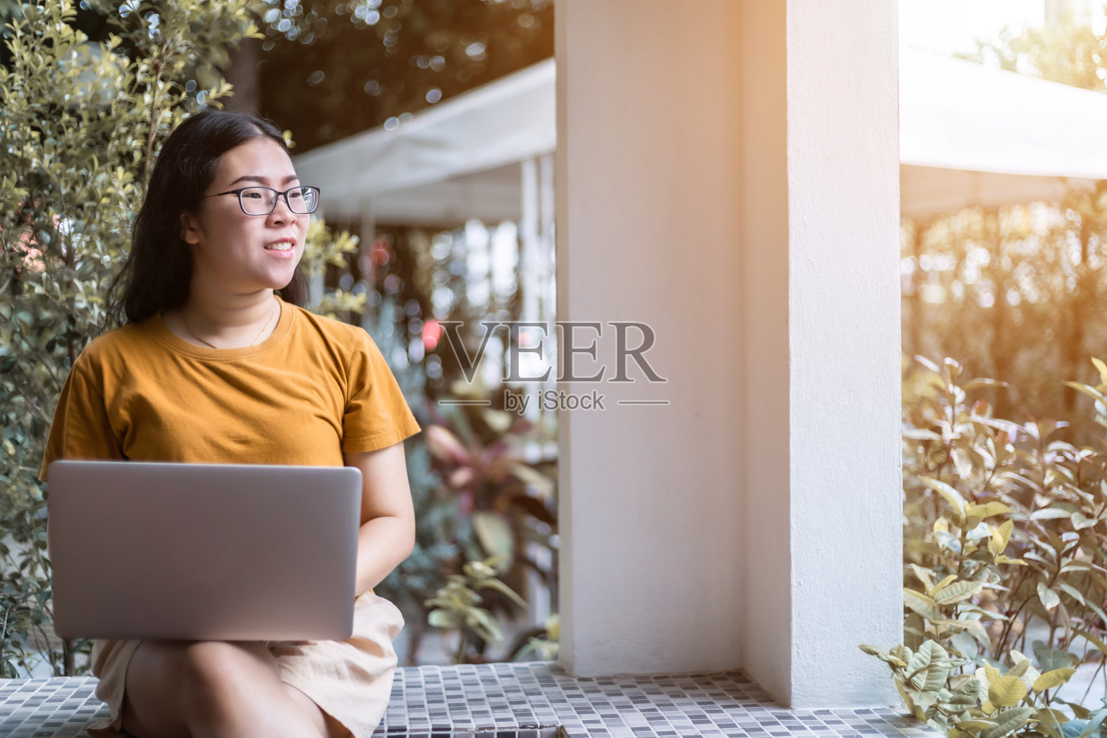 快乐的亚洲自由职业者商业女性休闲工作与笔记本电脑坐在咖啡馆长凳上的背景,沟通概念照片摄影图片