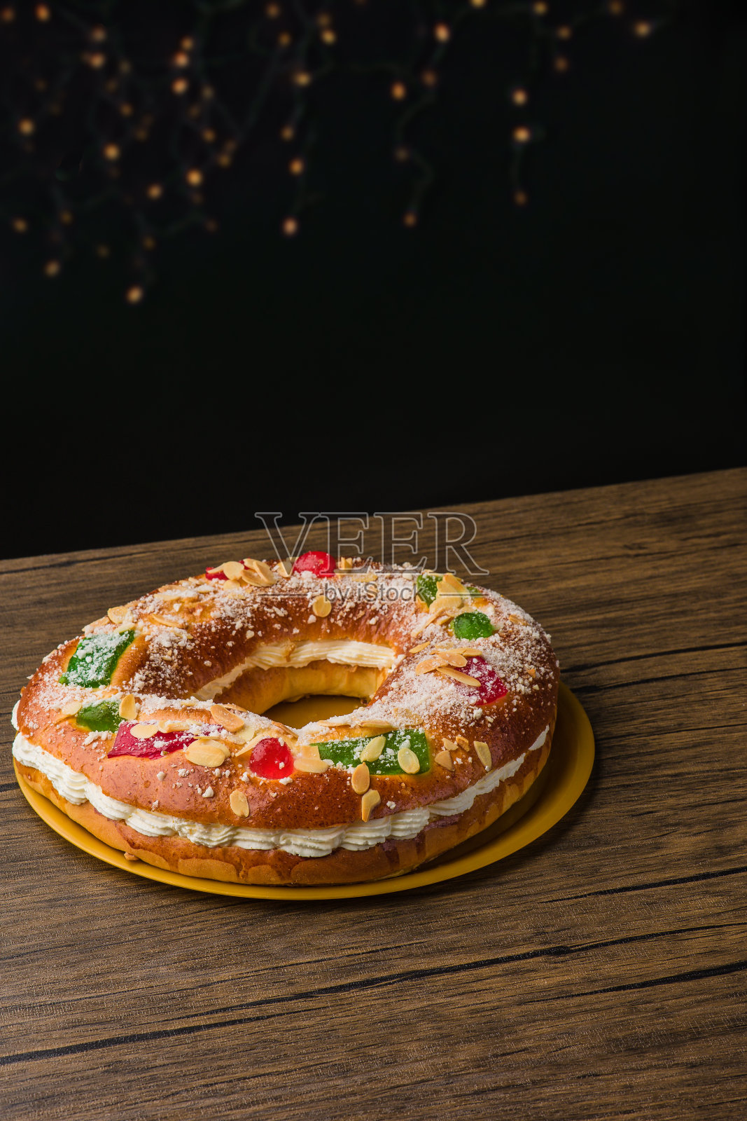 传统的西班牙圣诞食物蛋糕。Roscon de reyes背景与木制桌子上的装饰品照片摄影图片