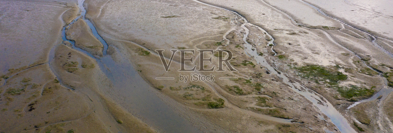 无人机拍摄的低潮时的泥滩海岸线,水在泥和沙洲中蜿蜒,荷兰,弗里斯兰照片摄影图片