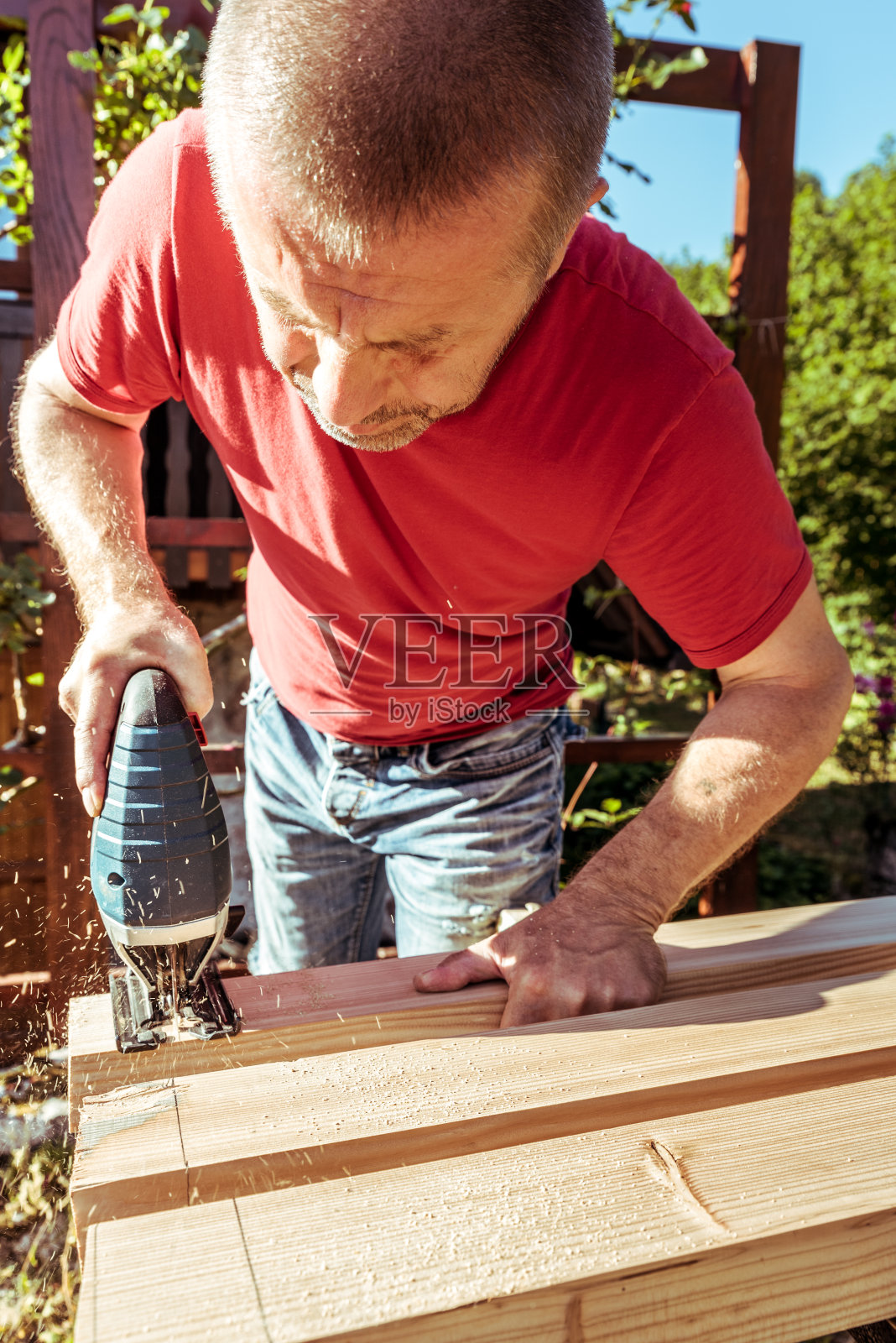 用电动竖锯锯木栅栏板的人照片摄影图片