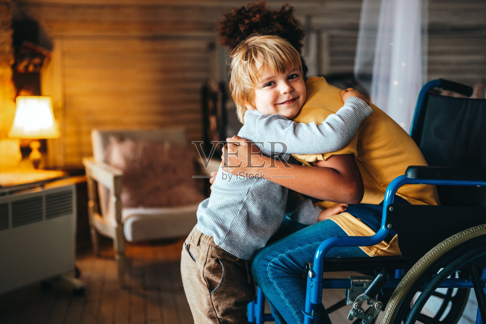 多民族家庭快乐。微笑着坐在轮椅上的残疾小女孩照片摄影图片