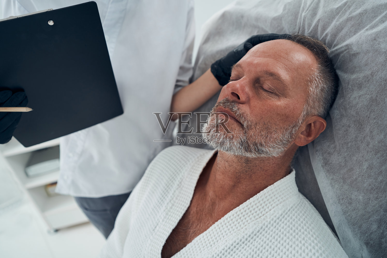 美容师在美容诊所检查男性头发照片摄影图片