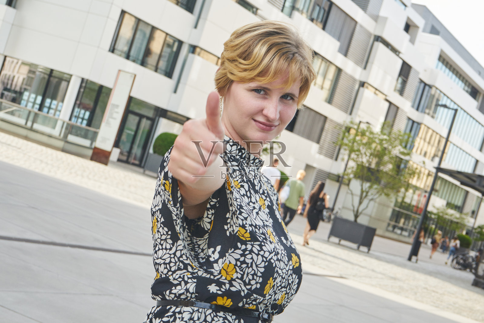 年轻的红头发女人举起了拳头照片摄影图片