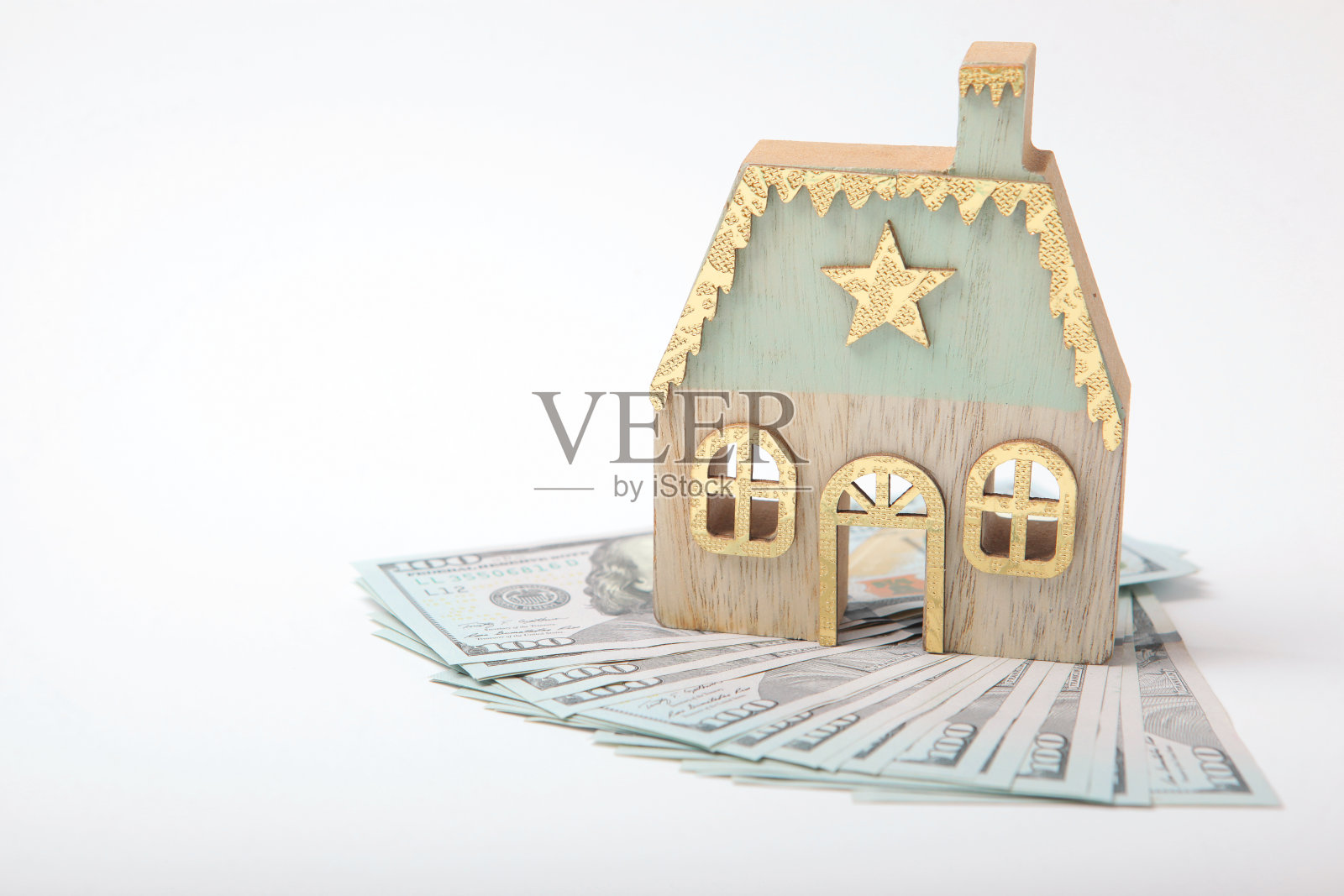 美钞和彩色背景上的房子小雕像。抵押贷款照片摄影图片