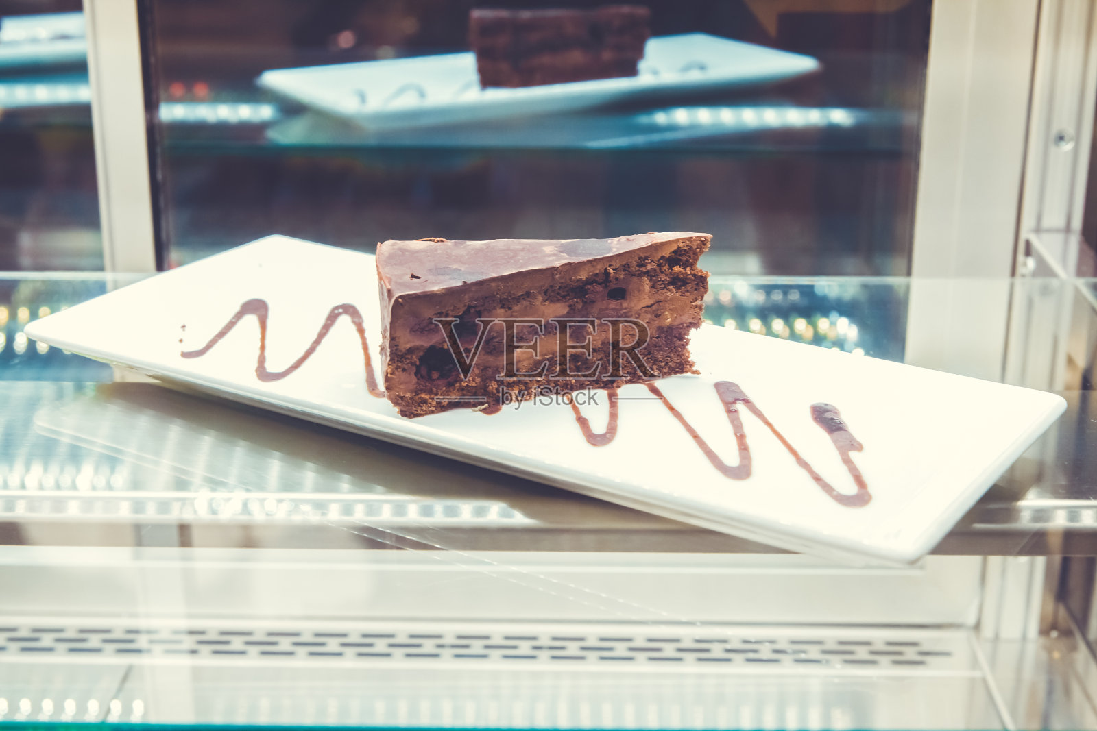 把巧克力酱倒在一块巧克力蛋糕上。黑巧克力酱松露蛋糕照片摄影图片