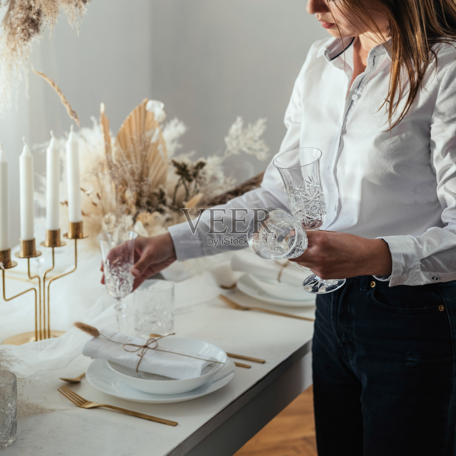 一个不知名的女人在家里摆好圣诞餐桌照片摄影图片