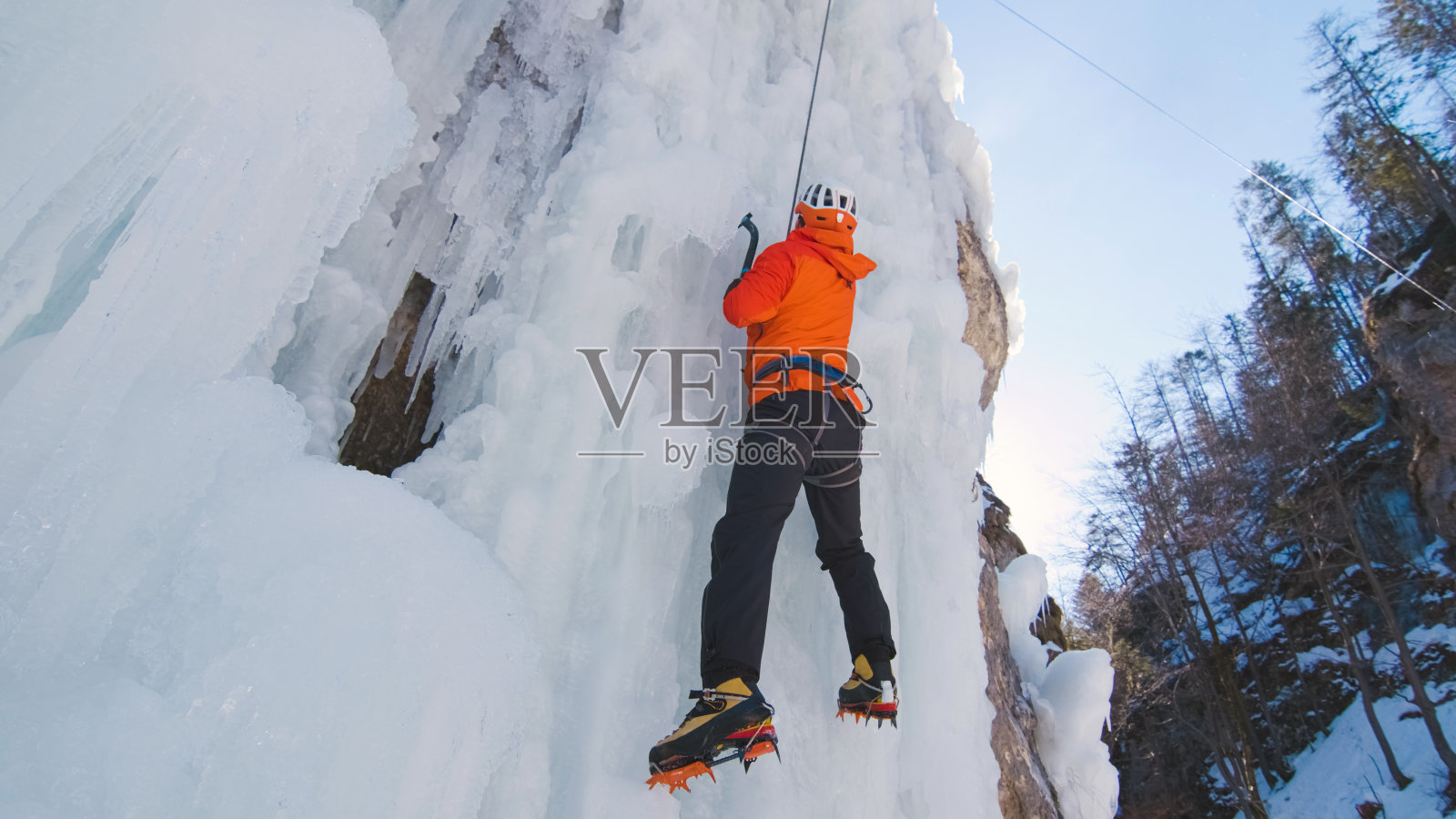 男子在冰上垂直攀爬照片摄影图片