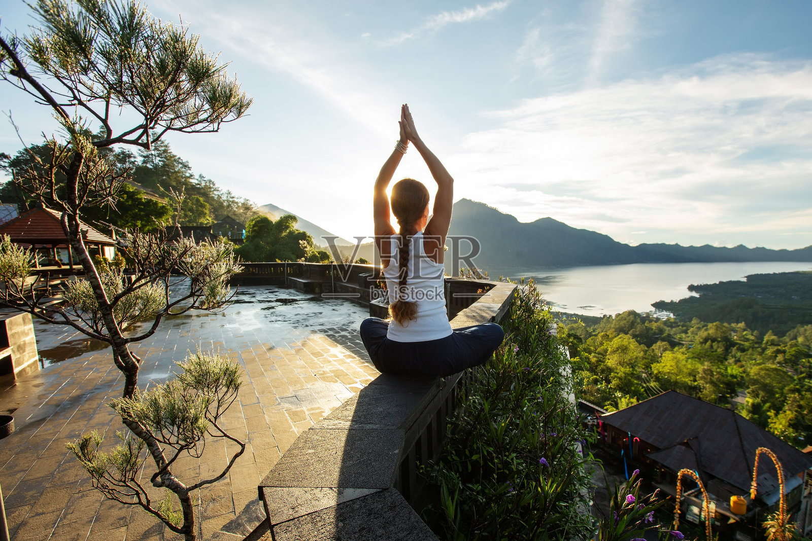 黎明时分,一名女子在巴厘岛的一座火山附近做瑜伽照片摄影图片