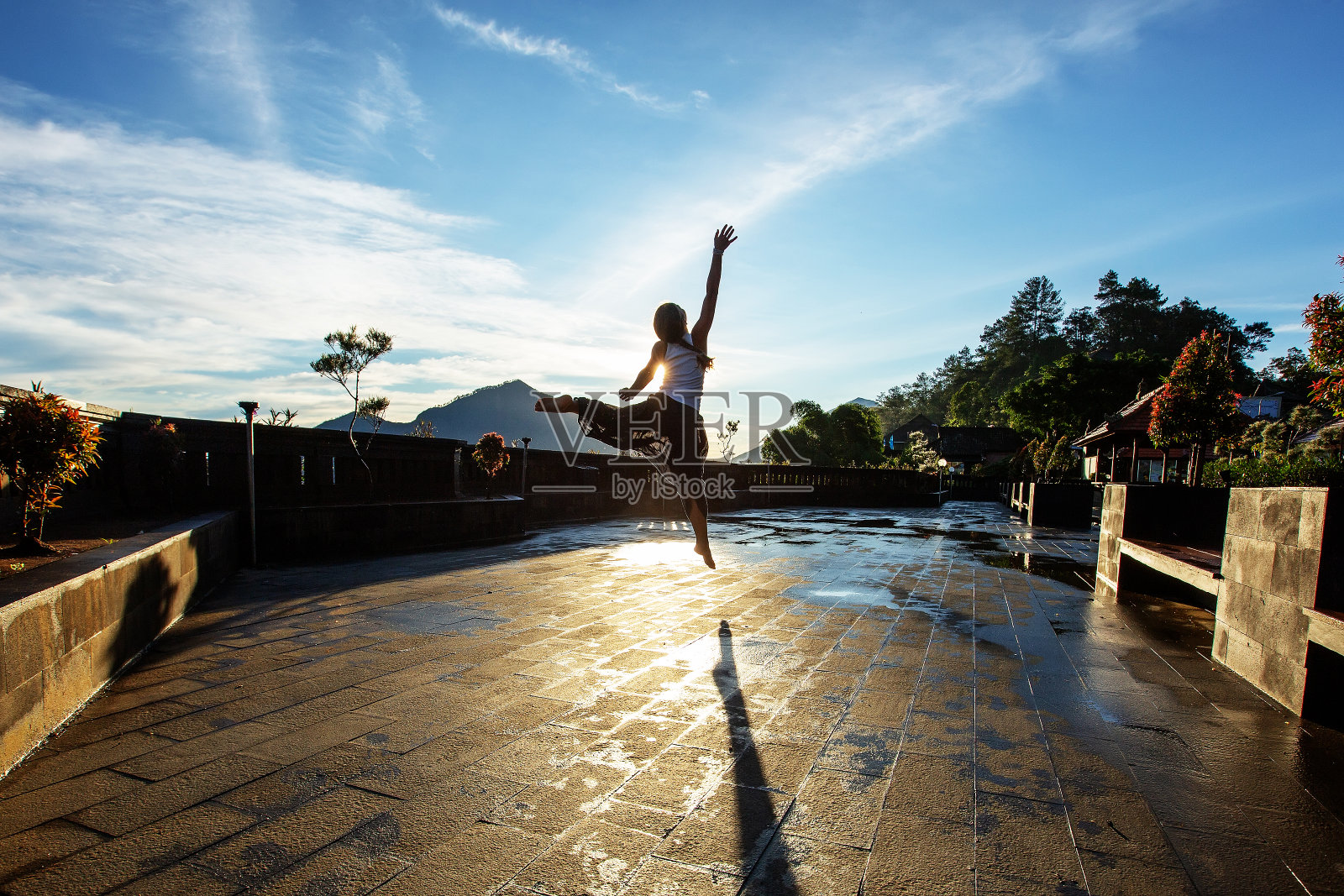 黎明时分,一名女子在巴厘岛的一座火山附近做瑜伽照片摄影图片