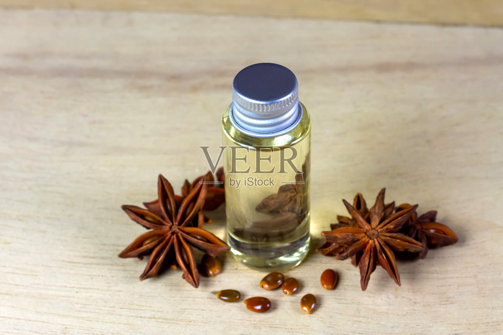 玻璃瓶里的茴香油放在木制背景上。茴香是烹饪和保健的原料。照片摄影图片