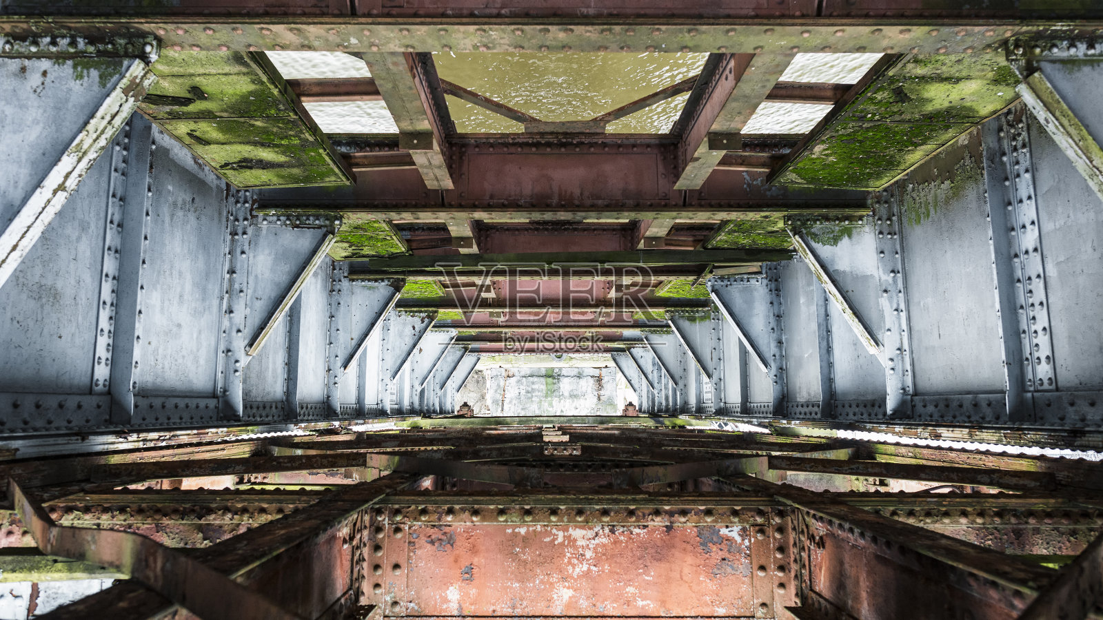 锈迹斑斑的旧铁路桥的金属结构,上面长满了青苔照片摄影图片