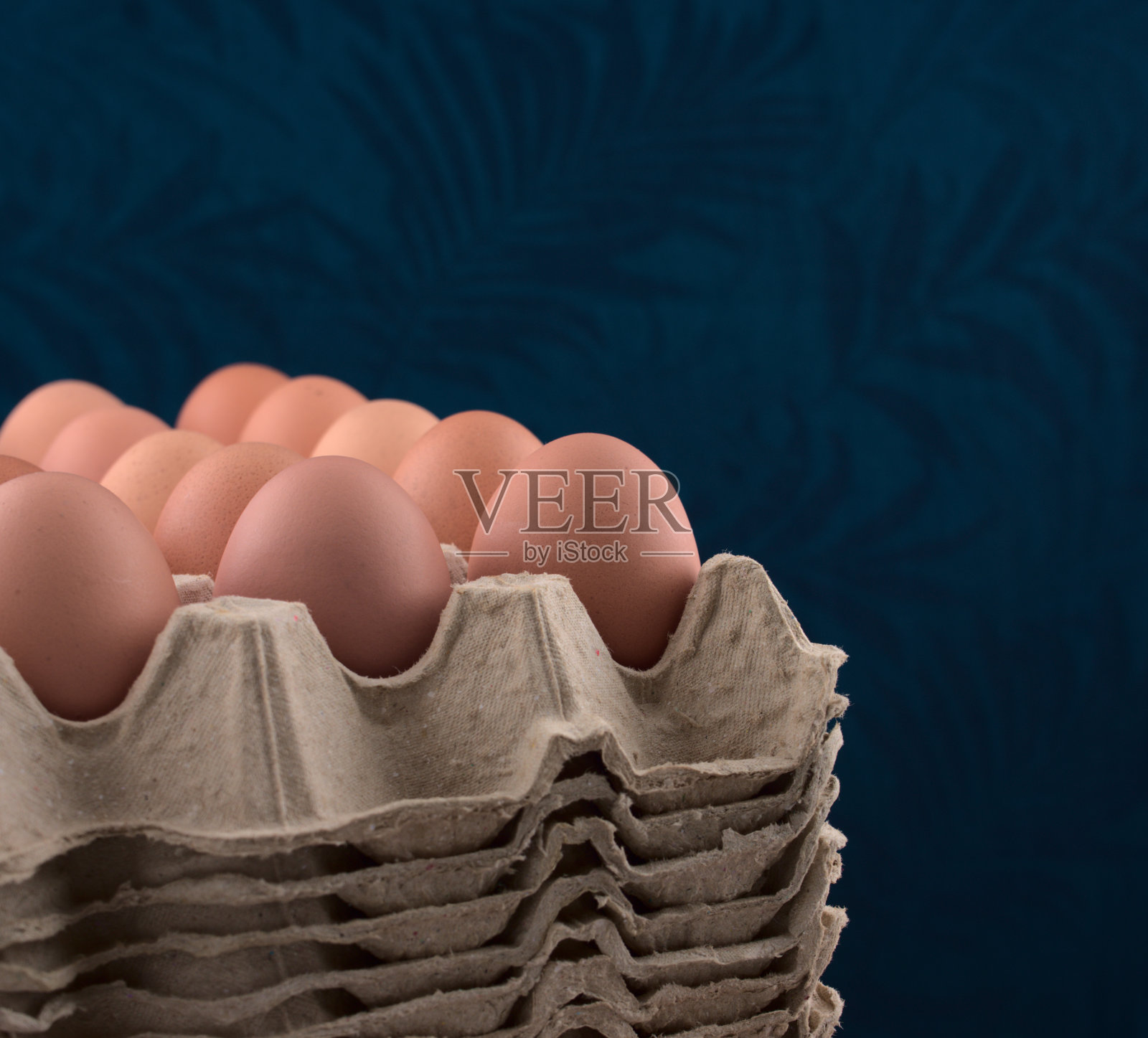 鸡蛋在纸箱对蓝色复古织物图案的背景。拍摄的。照片摄影图片