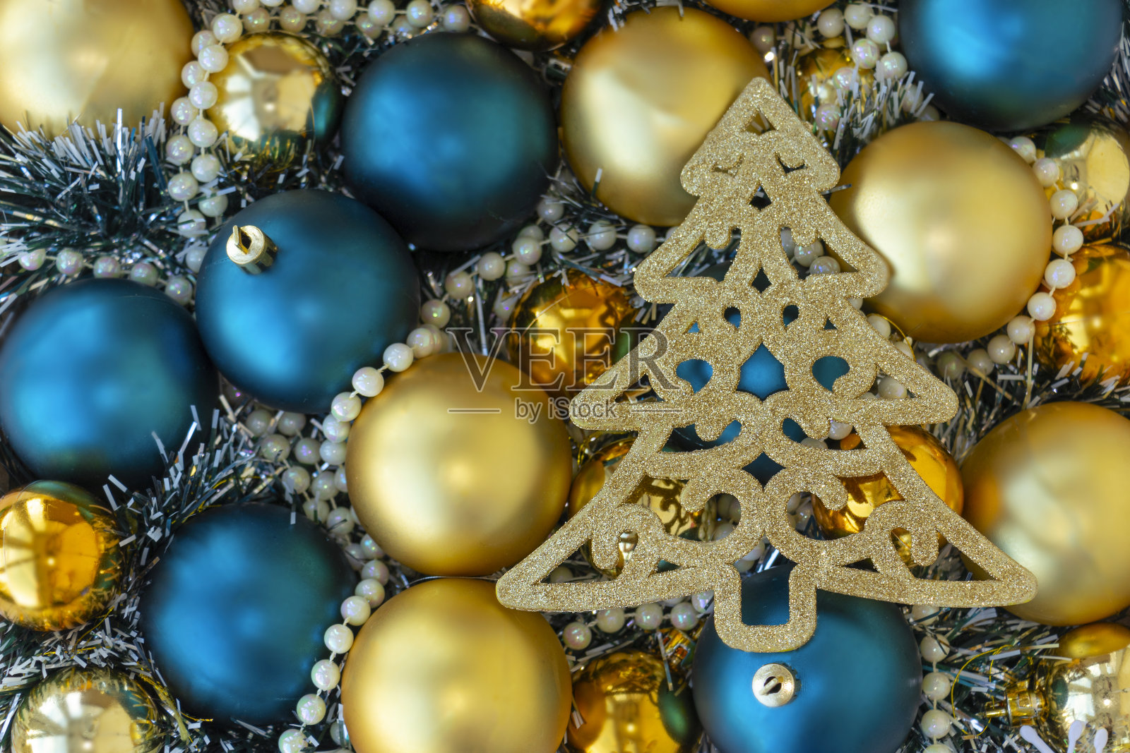 圣诞节或新年背景与金色和蓝色的圣诞球,金色的珠子和闪闪发光的金色圣诞树。俯视图照片摄影图片