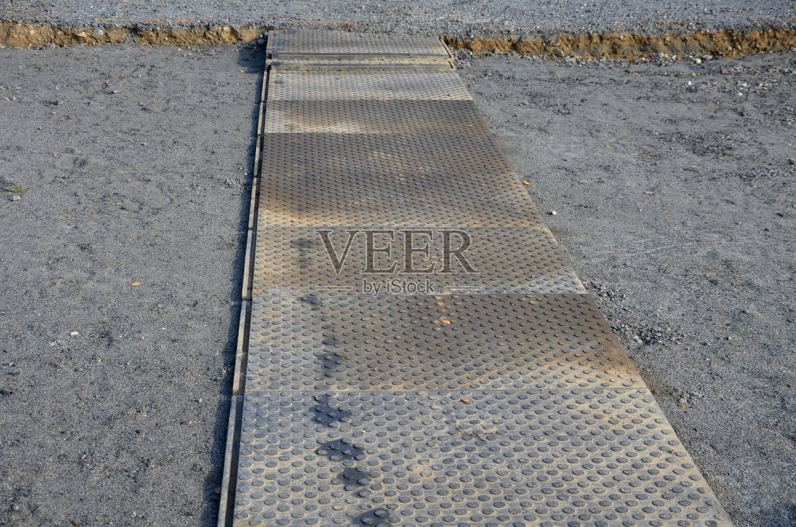 建筑工地临时人行道:橡胶防滑塑料,沥青路面上的绿色地毯和祈祷垫照片摄影图片