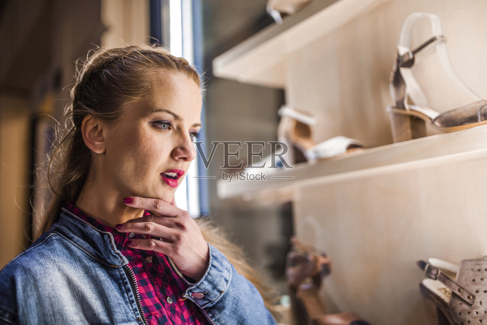 美丽的年轻女子走着,看着商店的橱窗照片摄影图片