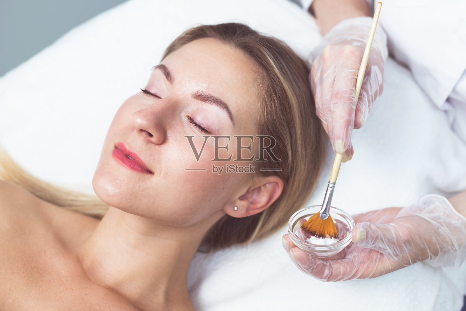 美容师给这位年轻女士敷面膜照片摄影图片