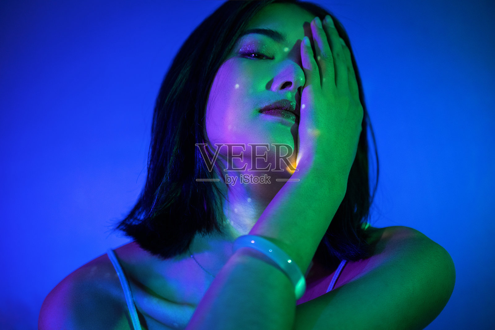 身着吊带裙的美丽女子被霓虹灯照亮照片摄影图片