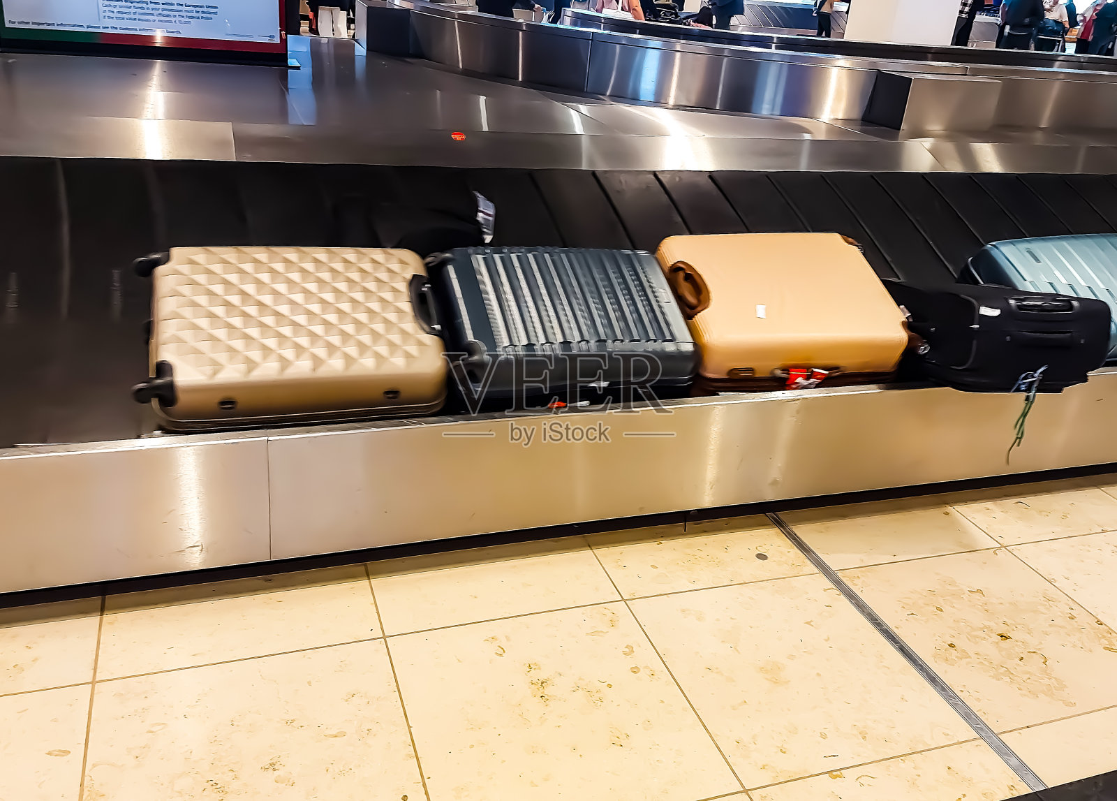 行李带上的行李箱——在机场处理行李照片摄影图片