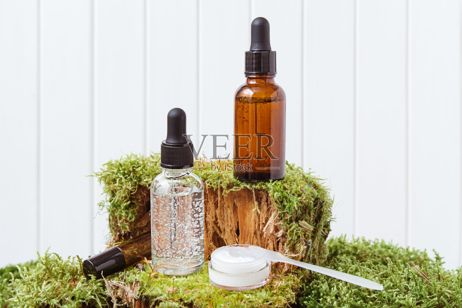 滴玻璃瓶模型上的绿色苔藓背景,自然的背景。环保护理有机产品。美容、按摩和水疗的概念。副本的空间。照片摄影图片