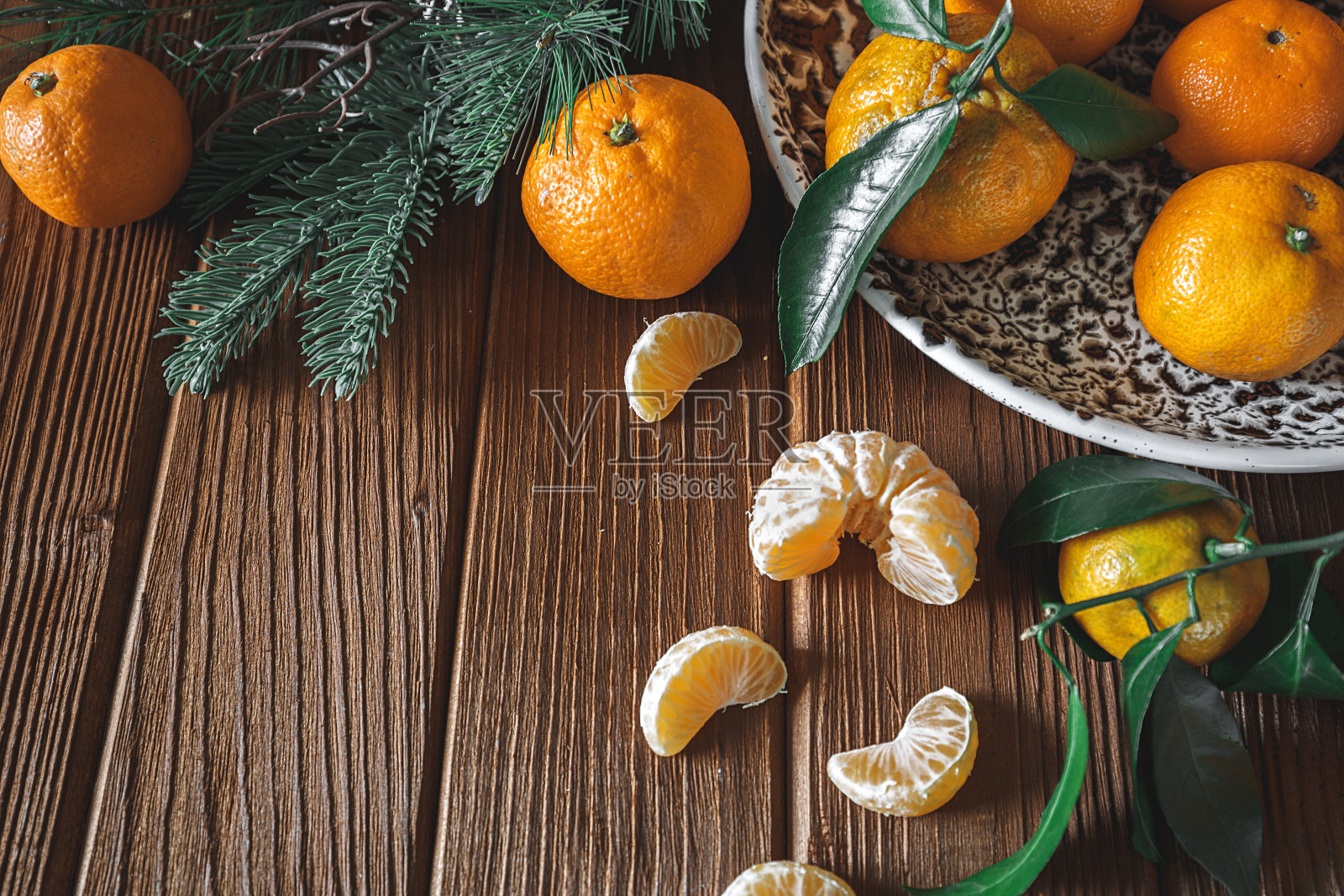 新鲜可口的柑橘,水果或带绿叶的橘子放在木桌上的碗里照片摄影图片