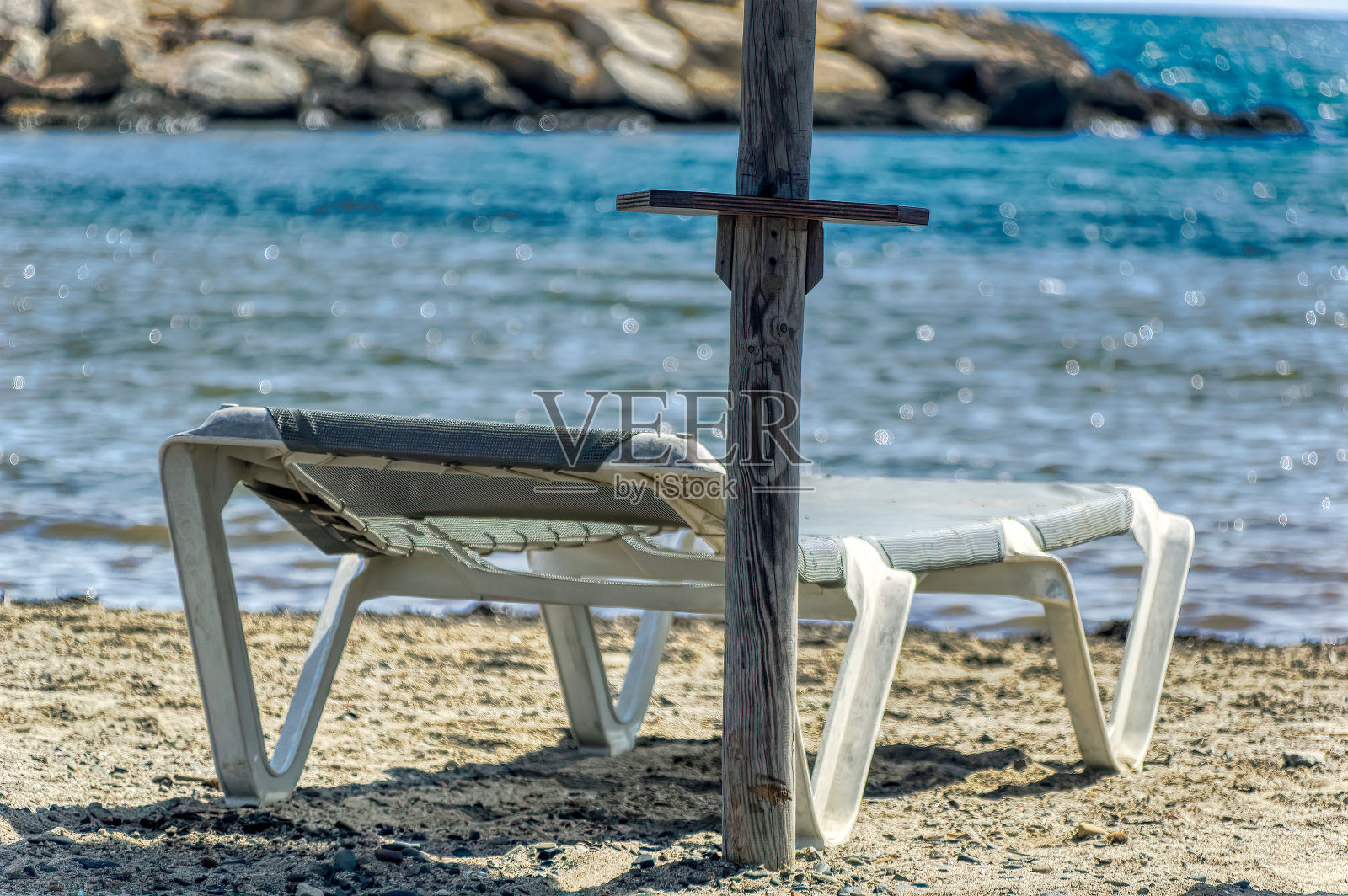 沙滩上一个在遮阳伞下的空太阳床。照片摄影图片