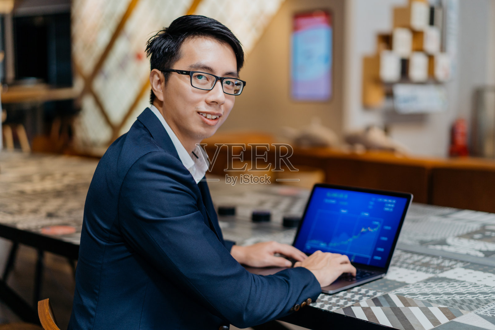 年轻的亚洲商人在共用办公空间使用笔记本电脑照片摄影图片