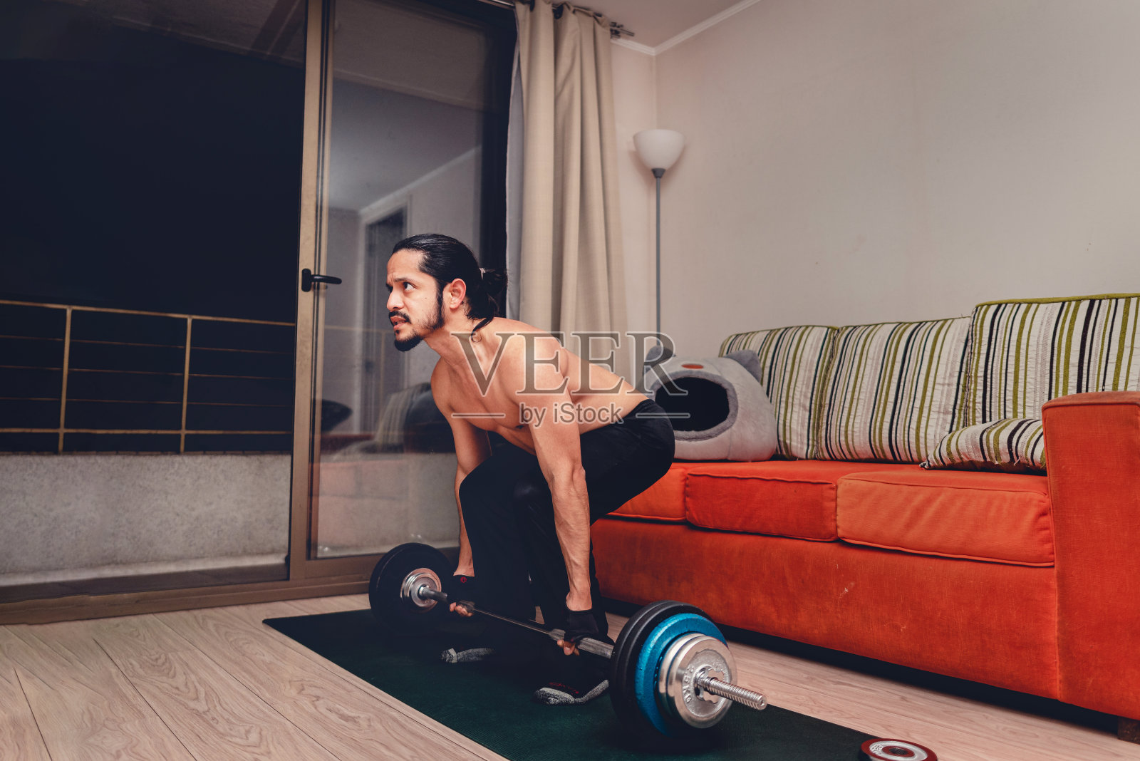 年轻人在家里的客厅里锻炼体重照片摄影图片