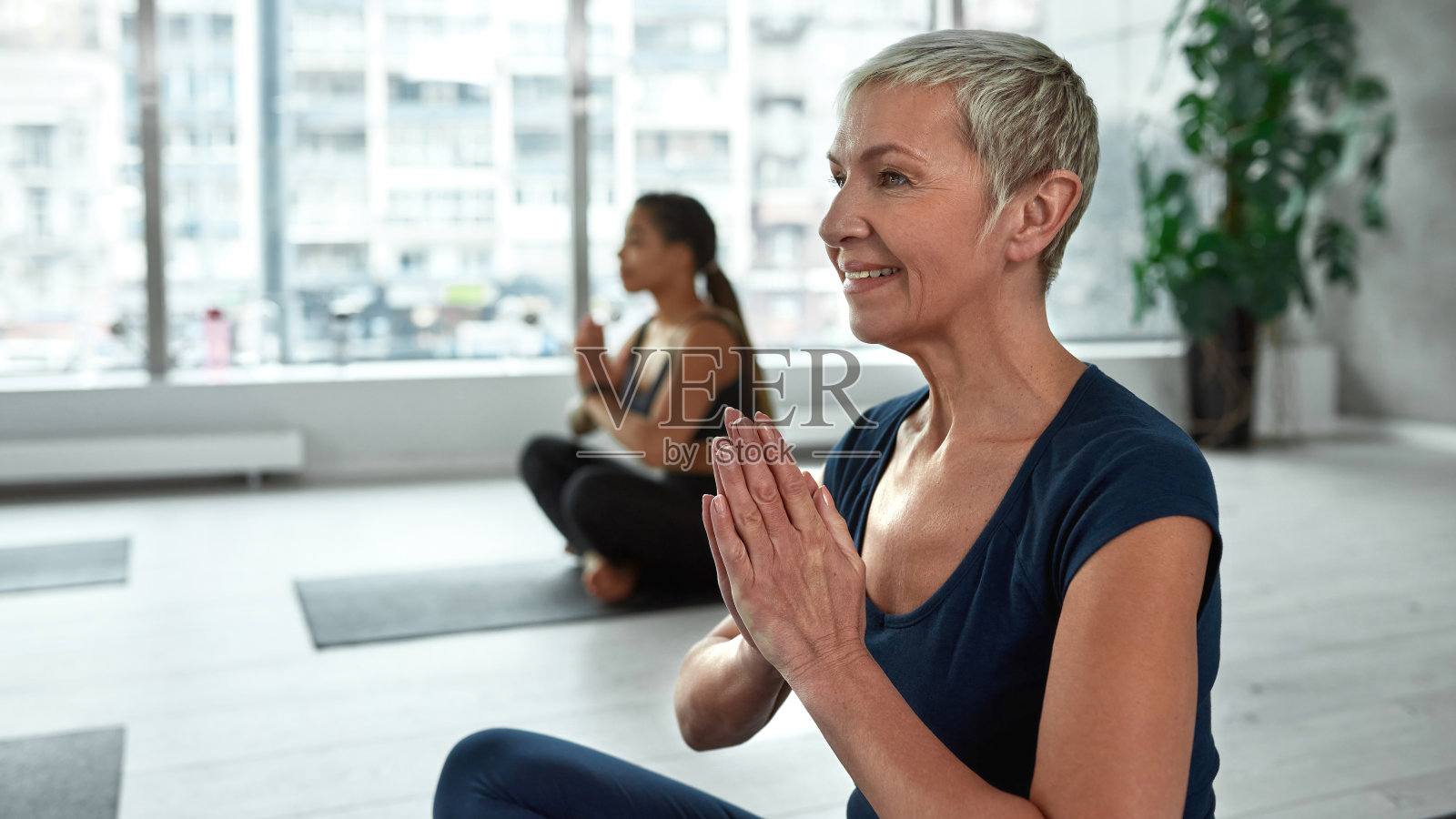 微笑活跃的50多岁妇女冥想练习瑜伽照片摄影图片