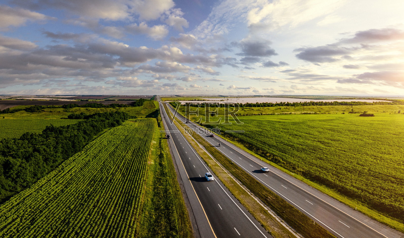 日落时一条高速公路穿过农田的鸟瞰图照片摄影图片