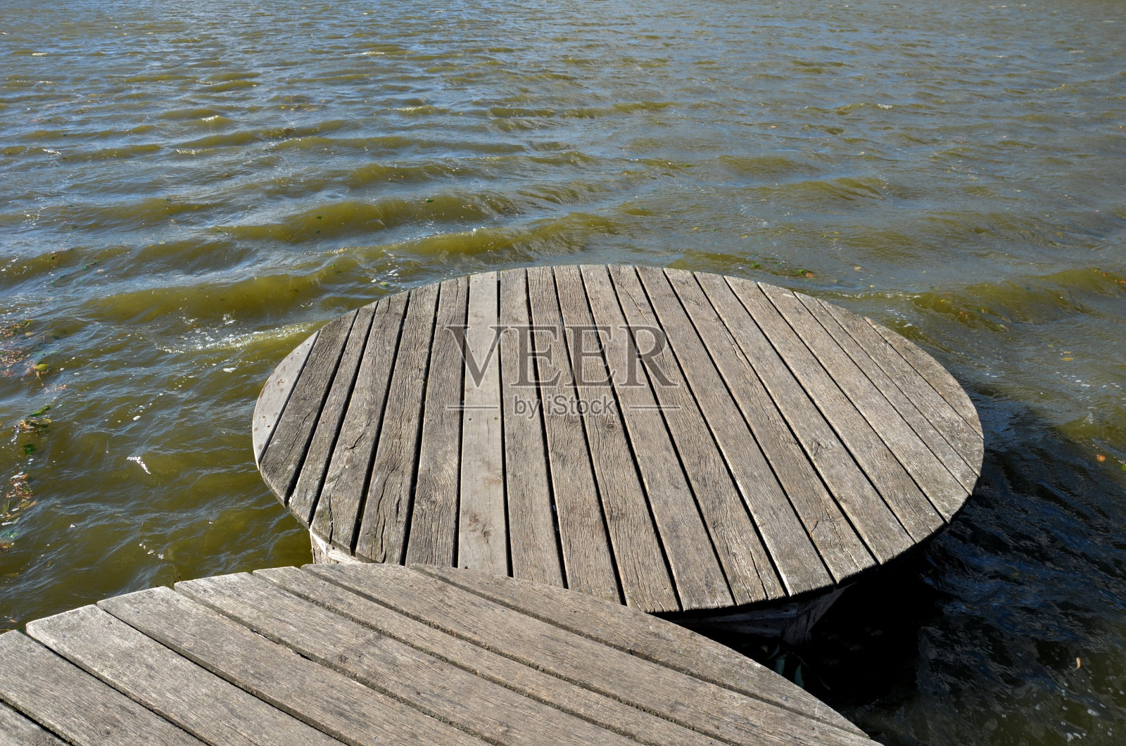 由木板制成的浮动走道。踩高跷上的狭窄弯曲的小路被推入湖底,高出湖水。没有栏杆。更多的设计走道由单独的圆形板制成。秋天防波堤照片摄影图片
