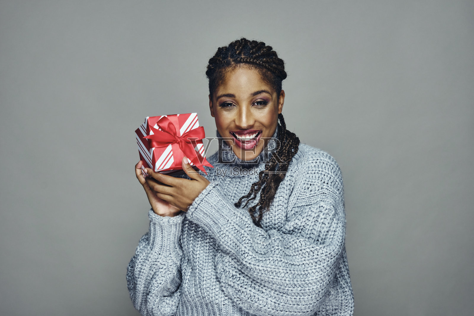 穿着毛衣的快乐女人手里拿着圣诞礼物照片摄影图片