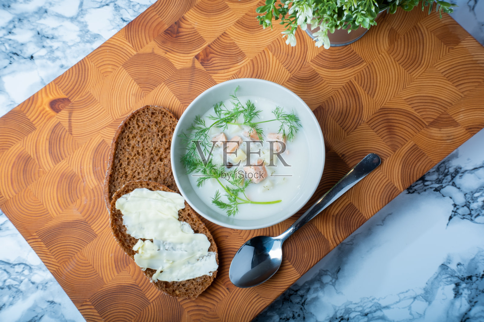 传统芬兰美食:一碗奶油鲑鱼汤,配上莳萝。旁边还有两片黑麦面包。照片摄影图片