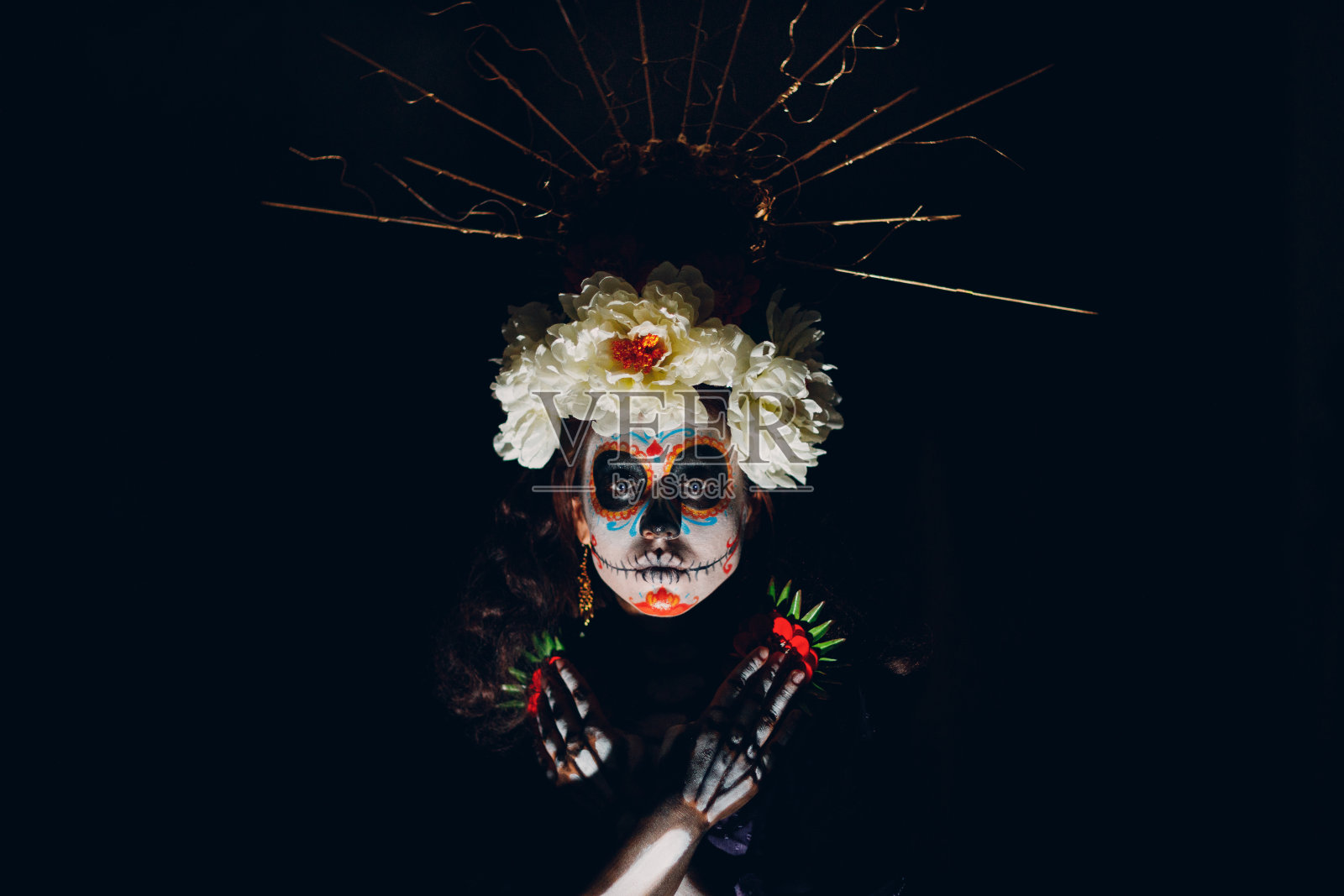 脸上画着墨西哥卡拉韦拉糖骷髅头万圣节妆的女人。亡灵节和万圣节狂欢节照片摄影图片